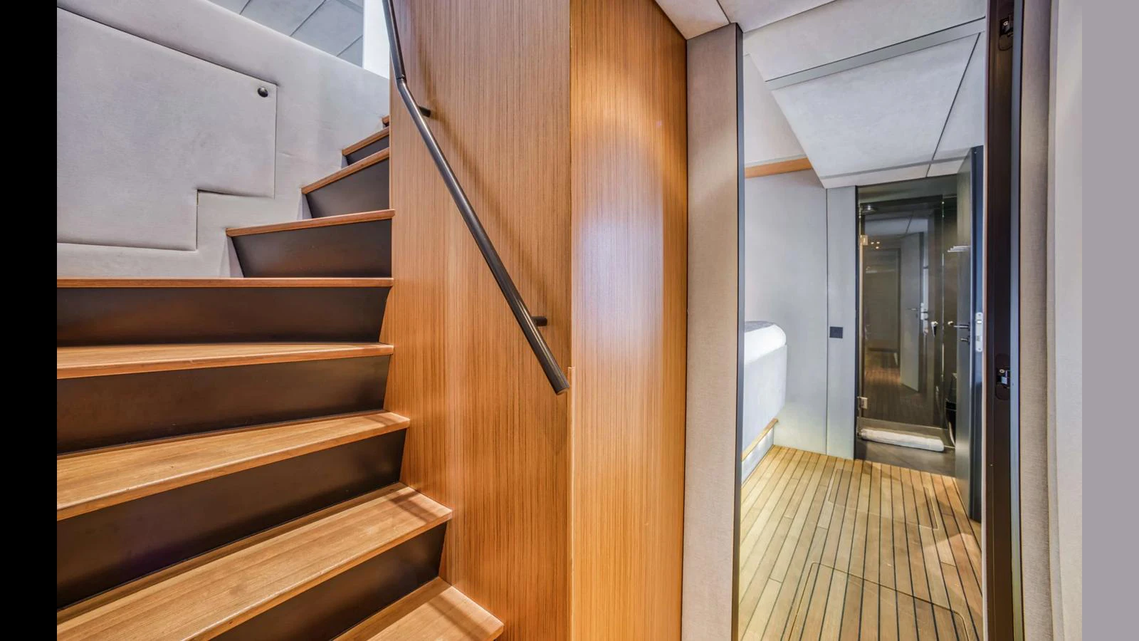 A modern interior with wooden stairs leading to a lower deck area. aboard MIDORI Yacht for Sale
