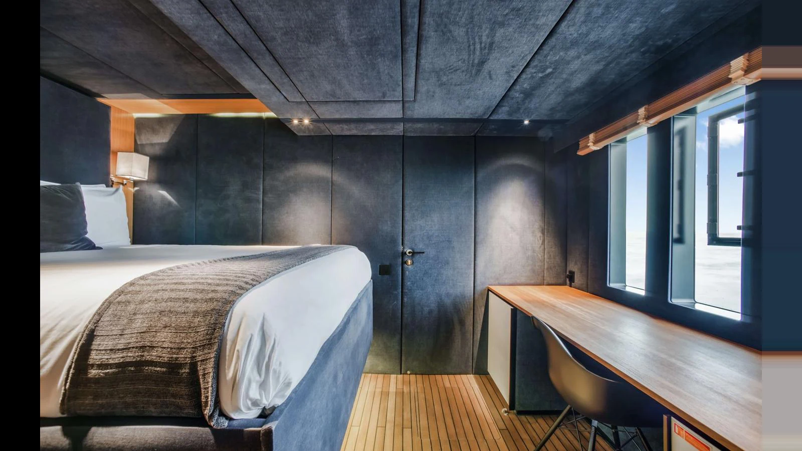 A modern stateroom featuring a cozy bed and a sleek wooden desk with a view. aboard MIDORI Yacht for Sale