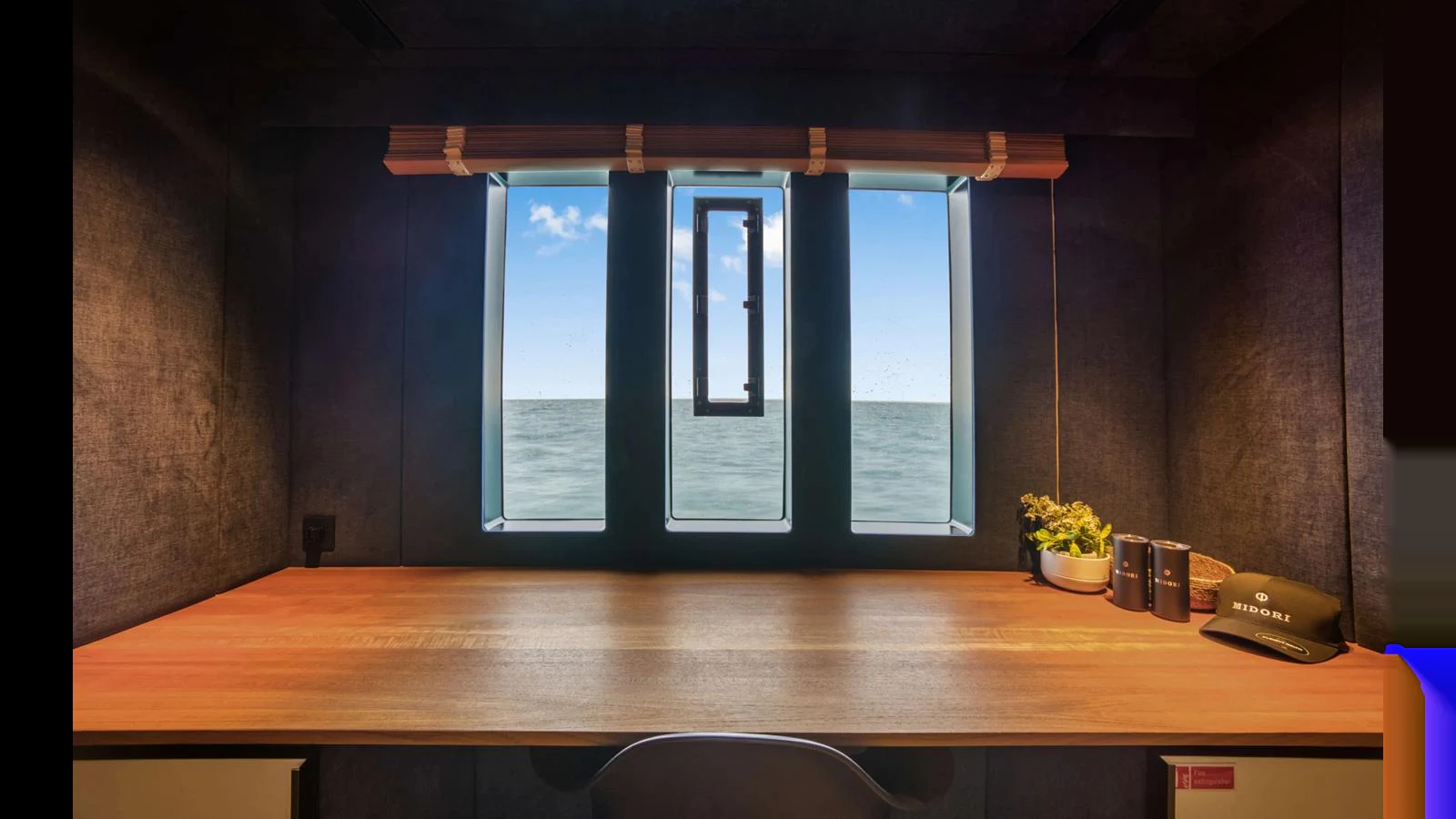 A cozy yacht office with a view of the sea through a window. aboard MIDORI Yacht for Sale