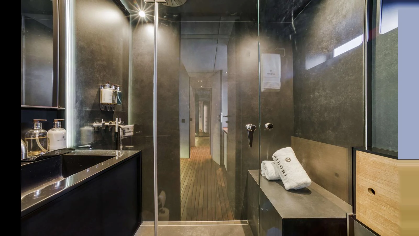 A sleek and modern bathroom with glass shower enclosure and elegant fixtures. aboard MIDORI Yacht for Sale