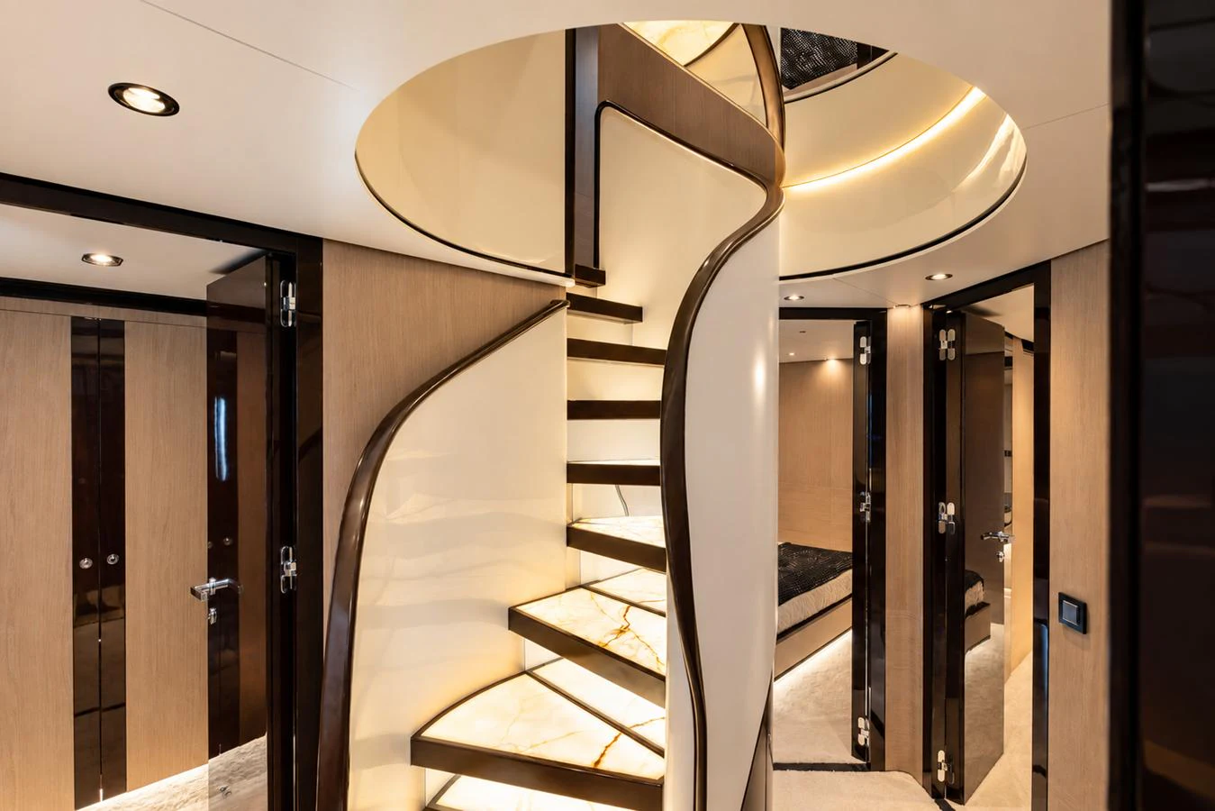 A luxurious interior featuring a modern spiral staircase with elegant lighting. aboard ESCAPE Yacht for Sale