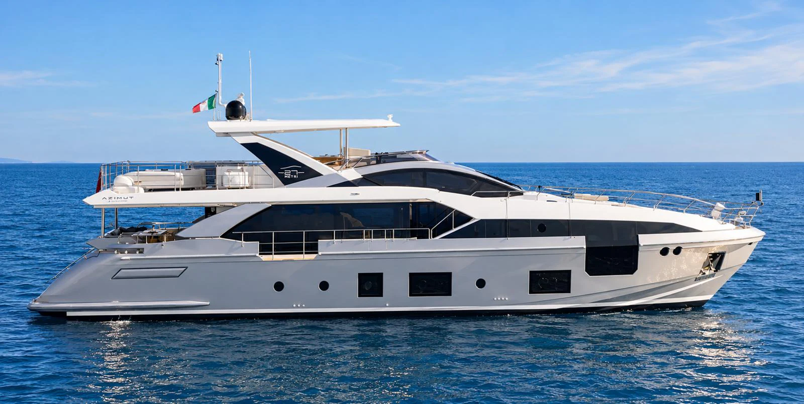 A sleek and modern yacht cruising on calm blue waters under a clear sky. aboard ESCAPE Yacht for Sale