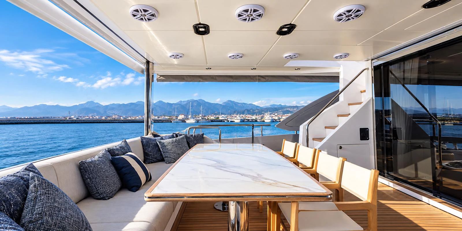 The aft deck features a spacious seating area with a large table, perfect for alfresco dining with a stunning view of the water. aboard ESCAPE Yacht for Sale