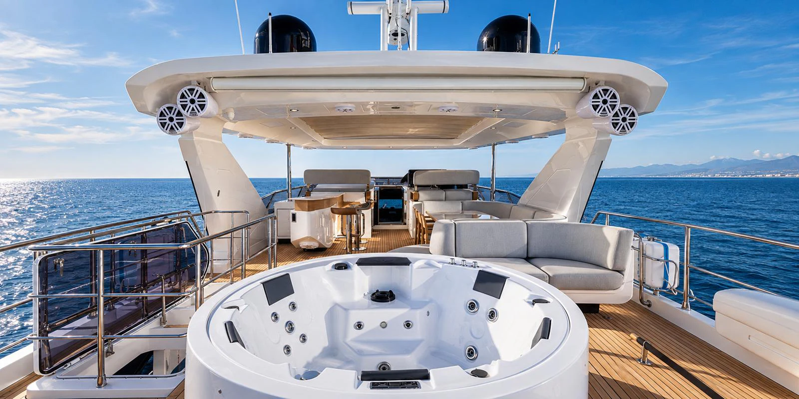 The sundeck features a luxurious jacuzzi with ample seating and stunning ocean views. aboard ESCAPE Yacht for Sale