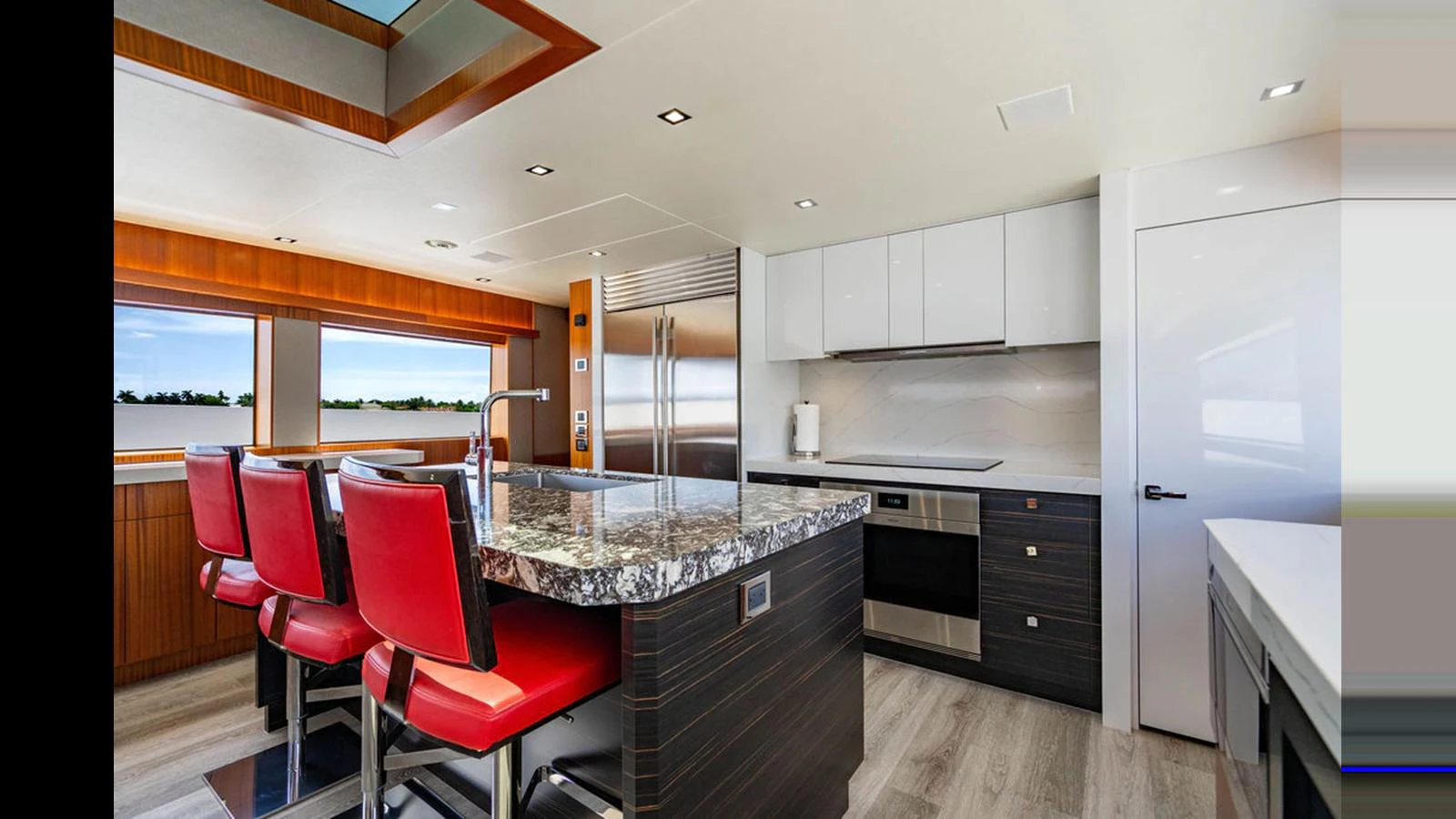 The yacht's galley features modern appliances, a sleek countertop, and comfortable seating. aboard TRU LUV Yacht for Sale