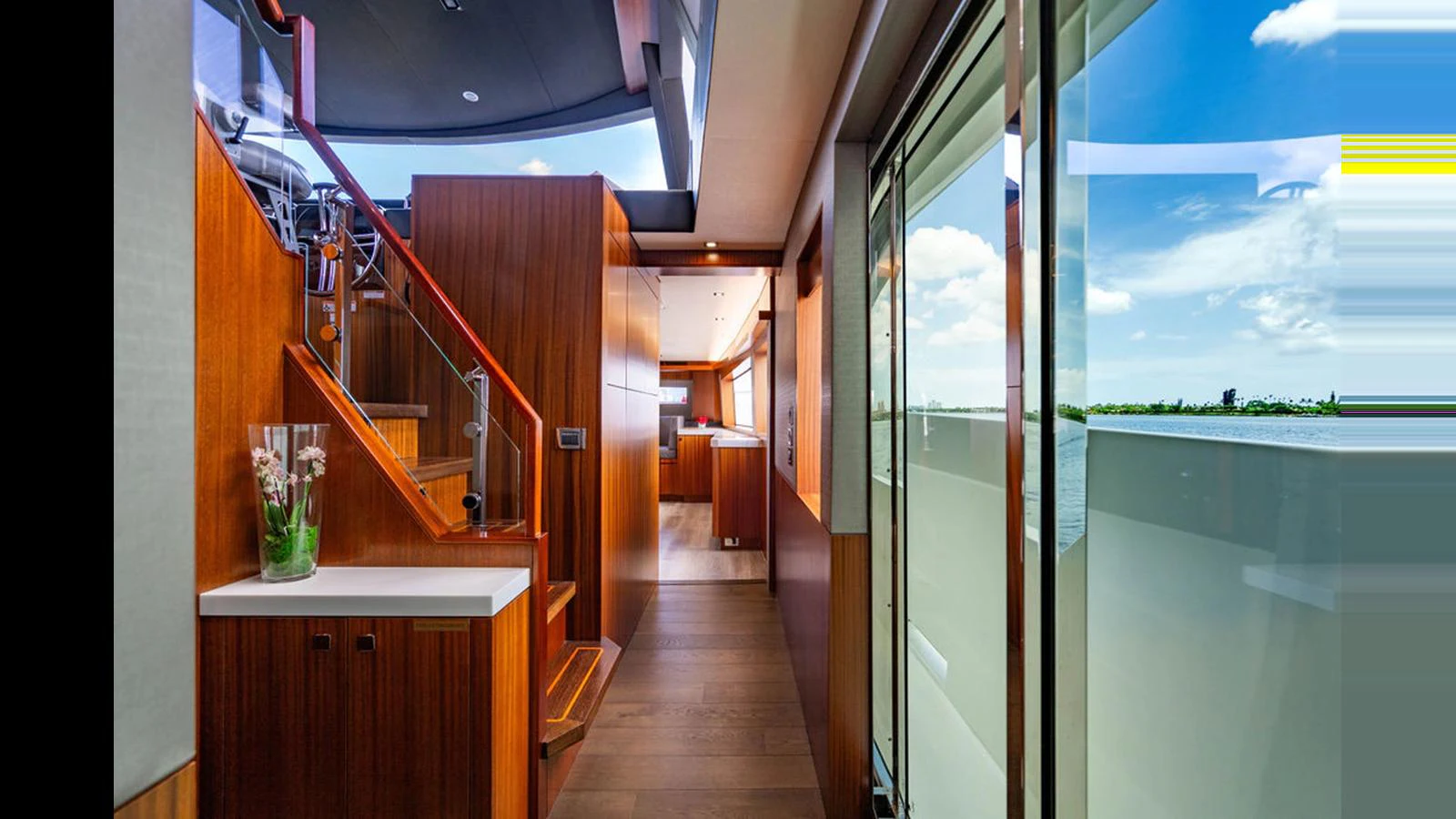 A beautifully designed interior hallway with wooden finishes and large windows offering stunning views. aboard TRU LUV Yacht for Sale