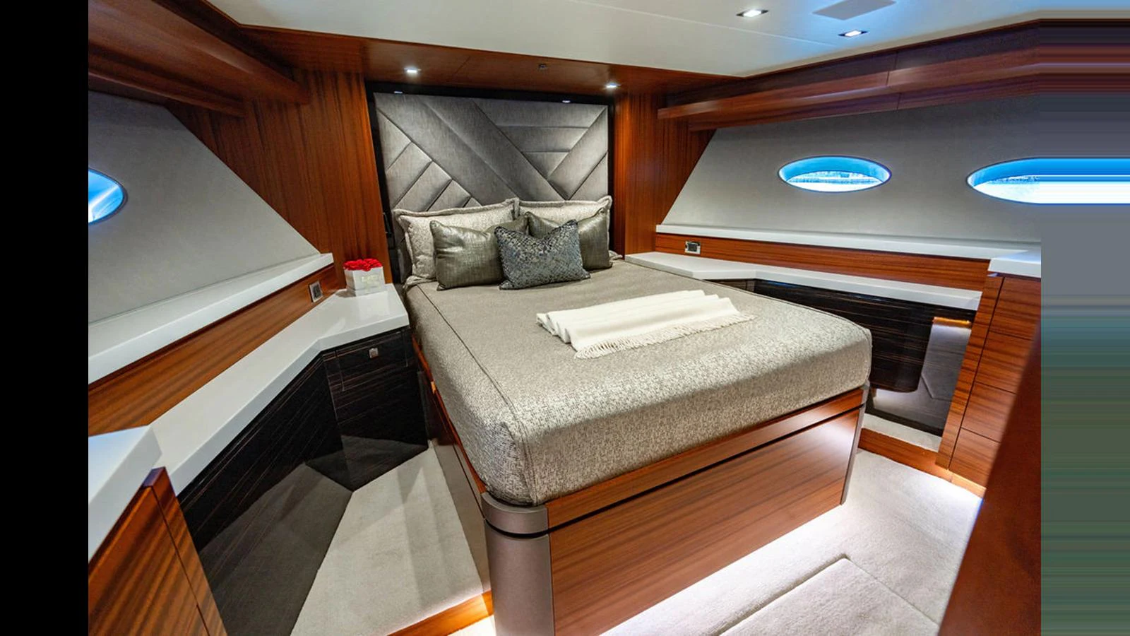 The stateroom features a luxurious bed with elegant wood paneling and modern lighting. aboard TRU LUV Yacht for Sale