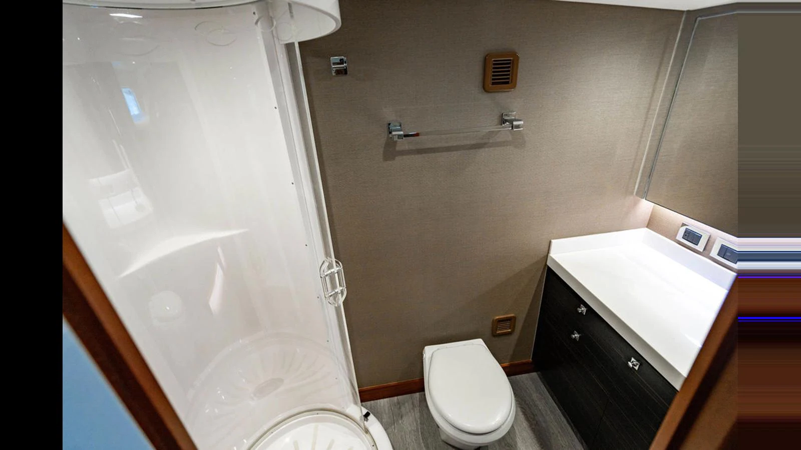 A modern yacht bathroom featuring a sleek shower, toilet, and vanity. aboard TRU LUV Yacht for Sale