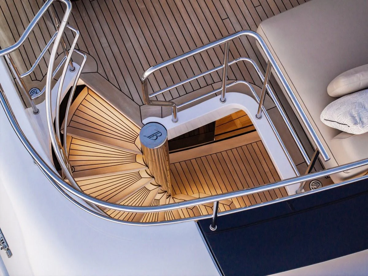 A beautifully crafted spiral staircase with teak decking and stainless steel railings. aboard CADA DIA Yacht for Sale