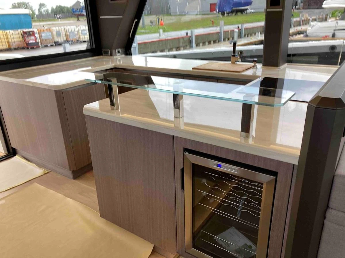 The yacht's galley features modern cabinetry, a sleek glass countertop, and a built-in wine cooler. aboard GLN Yacht for Sale