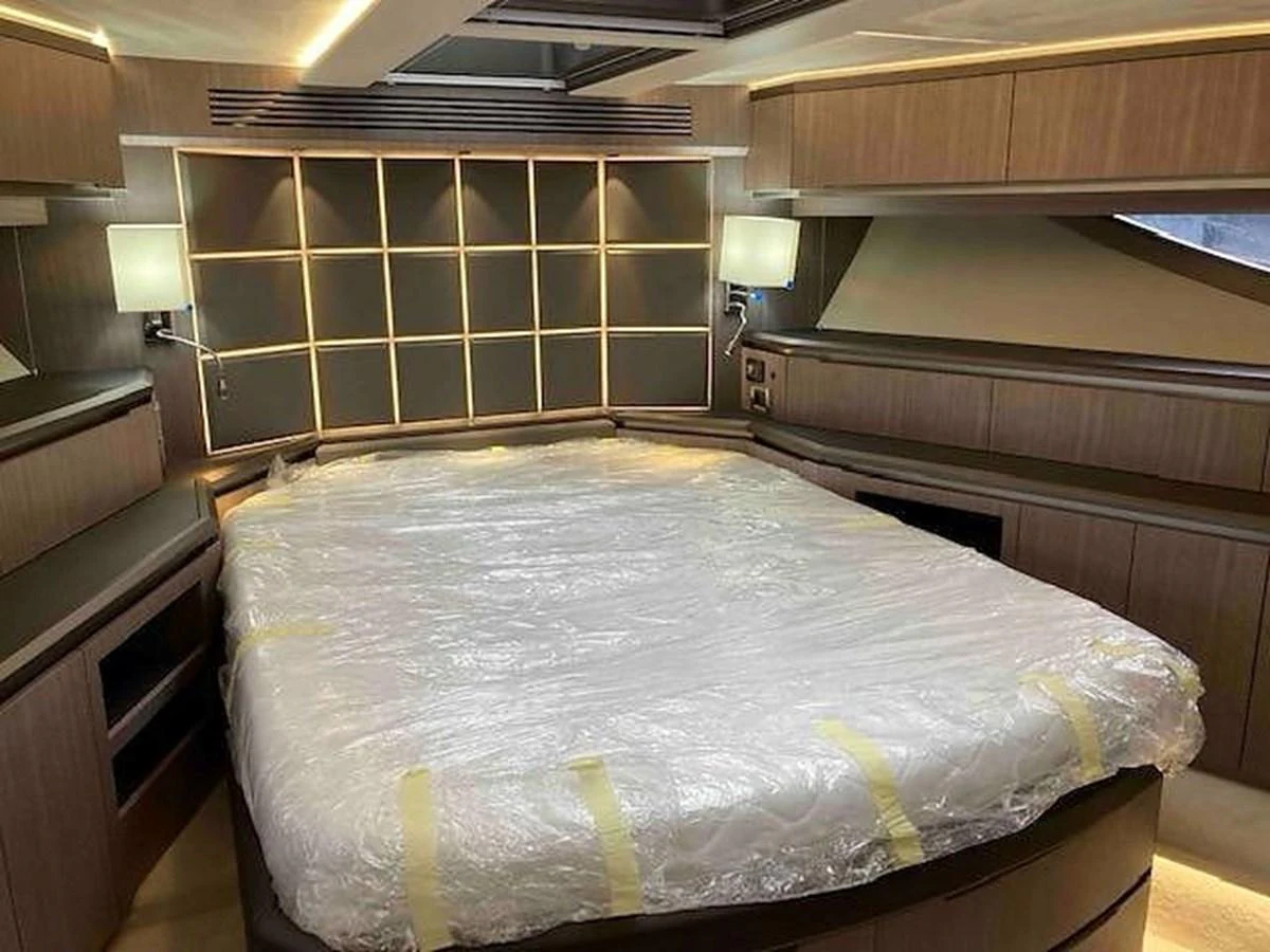 The master stateroom features a spacious bed with modern lighting and ample storage. aboard GLN Yacht for Sale