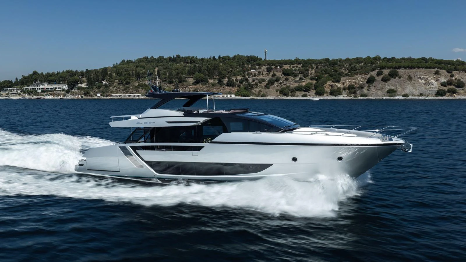 A sleek and modern yacht cruises swiftly through calm waters against a scenic coastal backdrop. aboard CREA Yacht for Sale