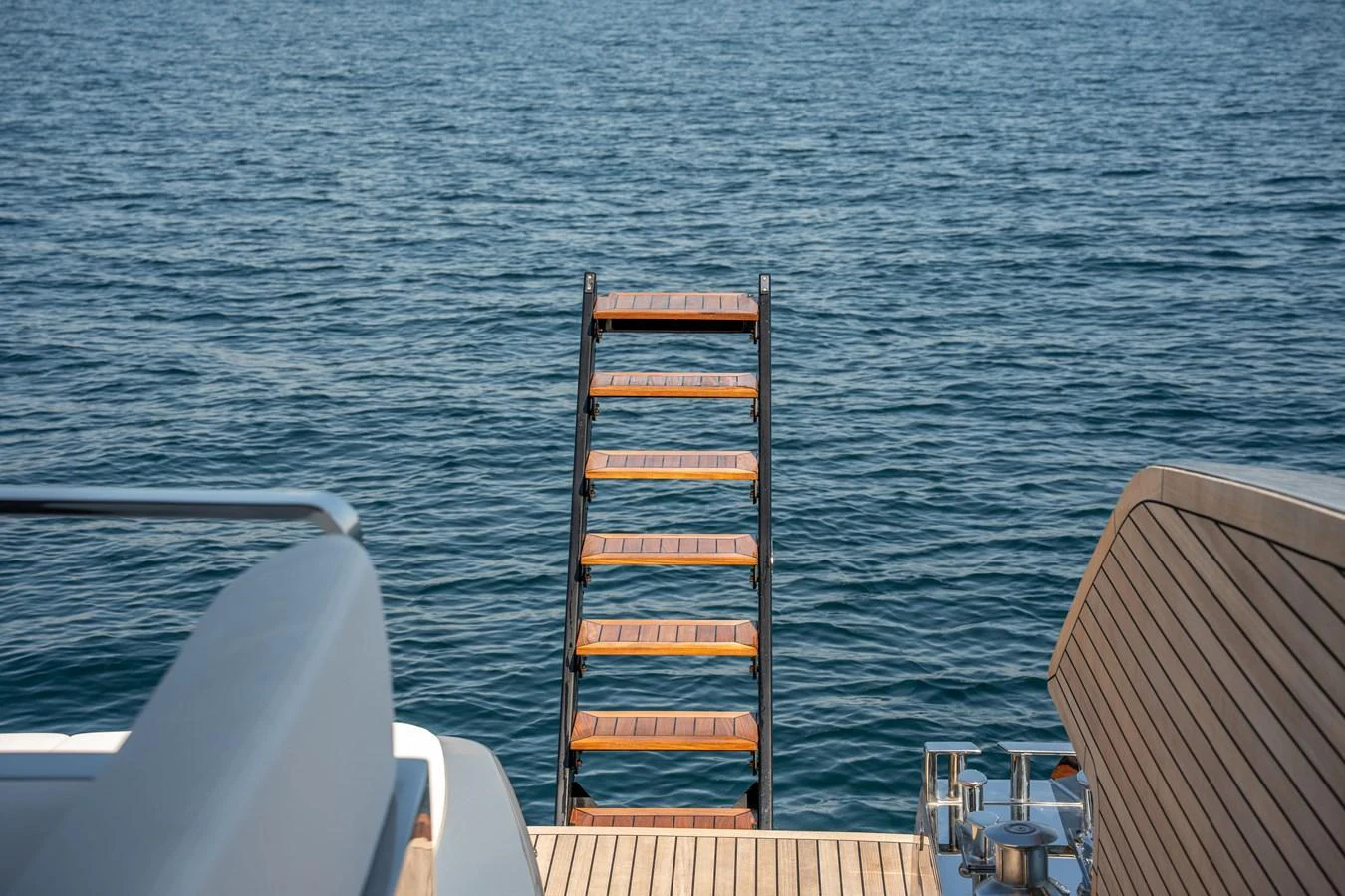 A view of the yacht's swim platform with a ladder extending into the water. aboard CREA Yacht for Sale