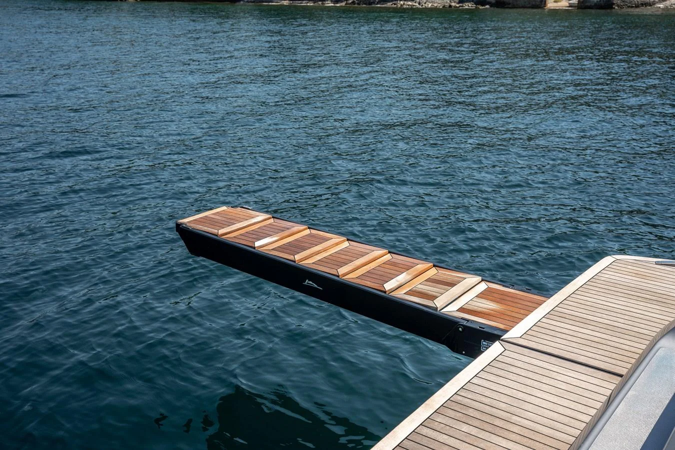 The image showcases a sleek, extendable boarding platform extending over the water. aboard CREA Yacht for Sale