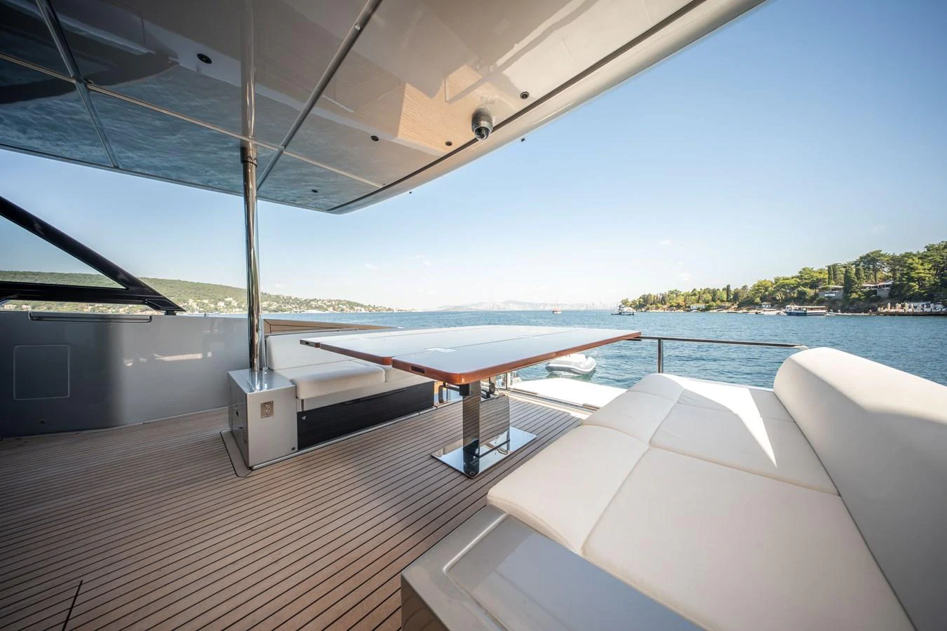 The aft deck features a spacious seating area and a sleek dining table with stunning views of the water. aboard CREA Yacht for Sale
