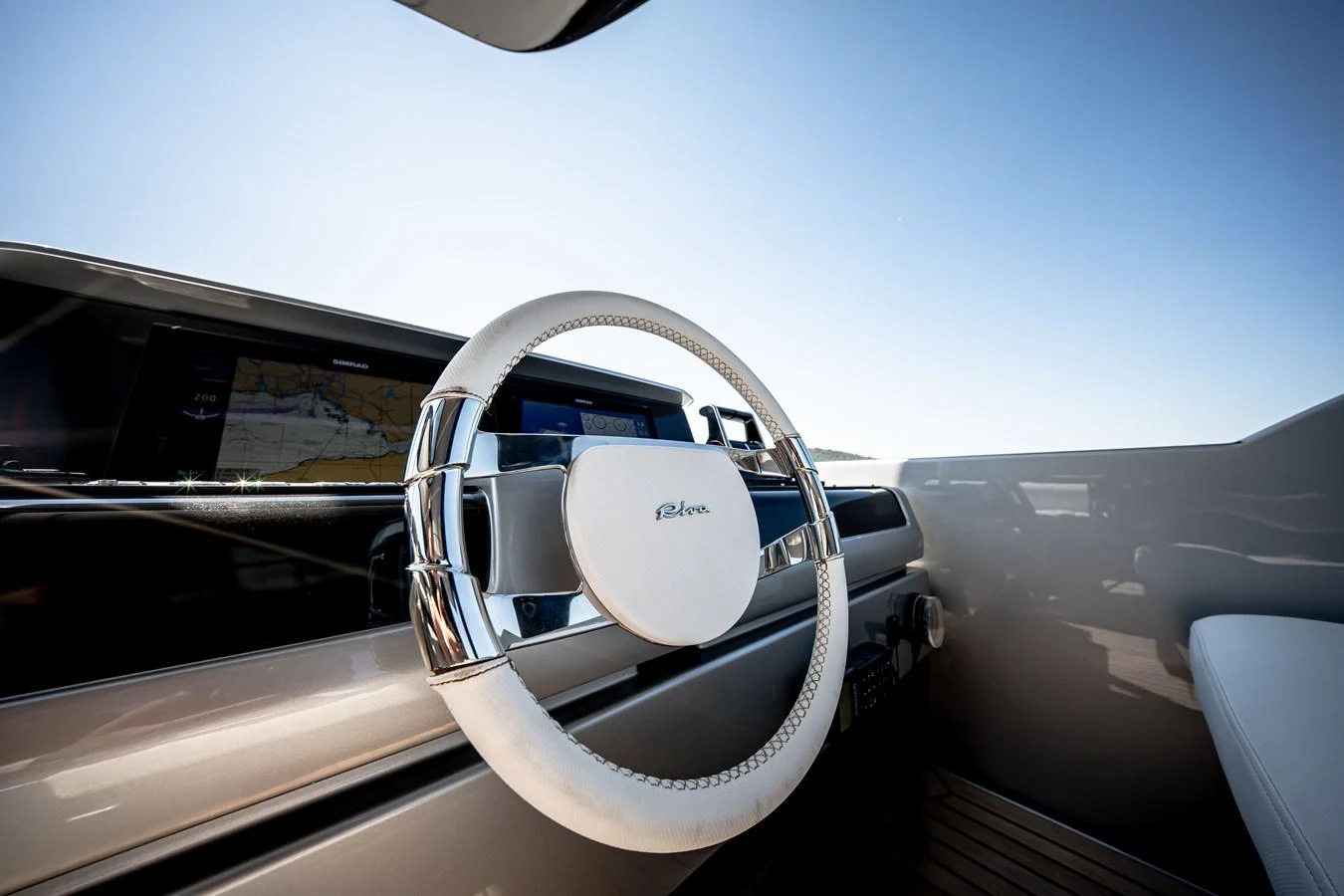 The helm features a sleek, modern steering wheel with polished chrome accents. aboard CREA Yacht for Sale