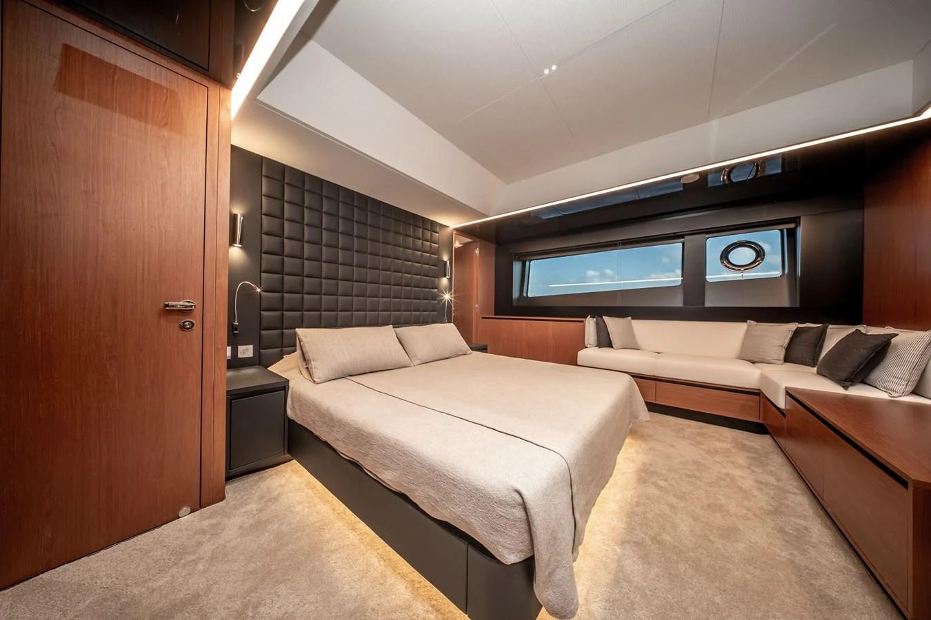 The master stateroom features a luxurious bed, elegant wood finishes, and ample natural light. aboard CREA Yacht for Sale