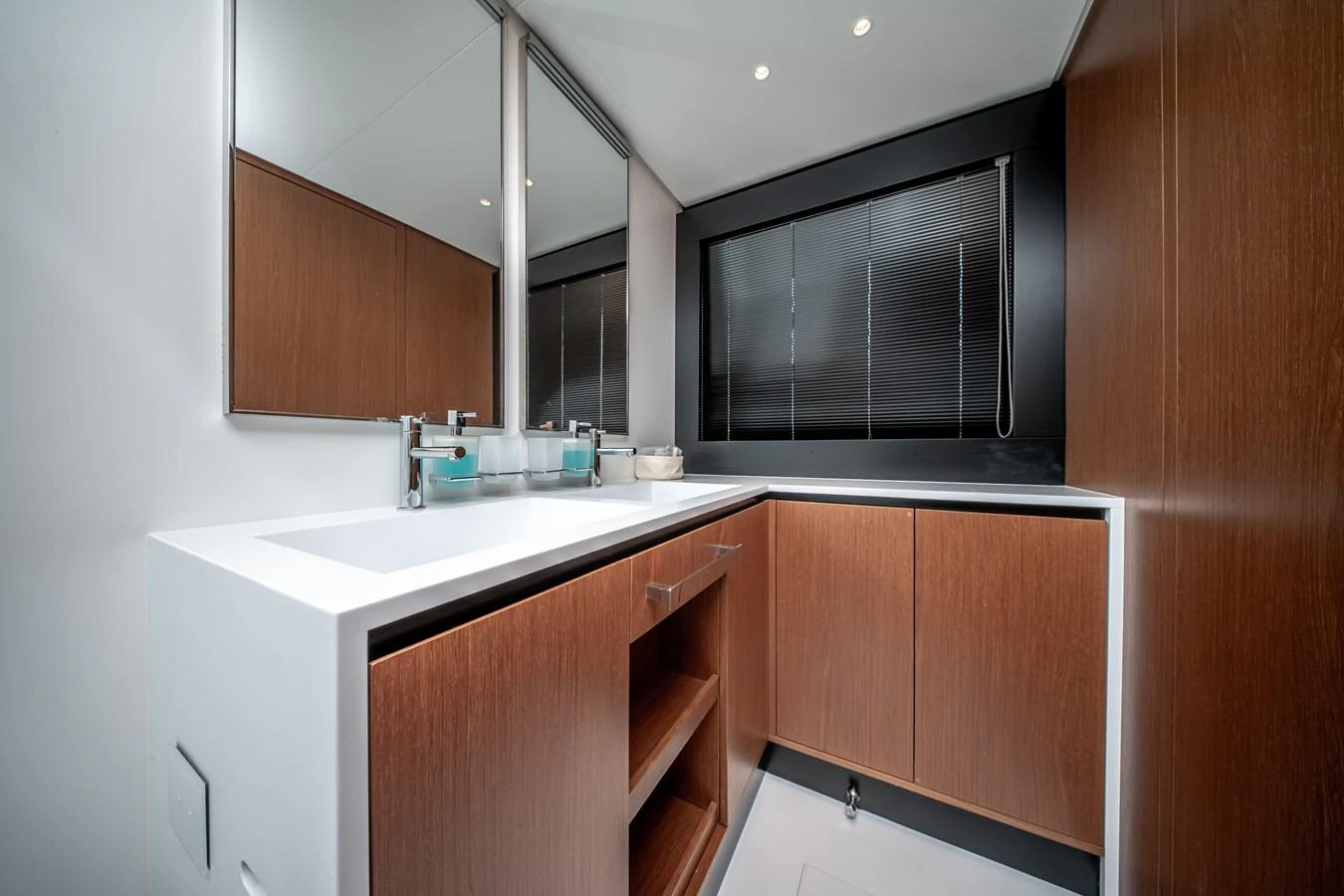 The yacht's bathroom features sleek wooden cabinetry and a modern sink area. aboard CREA Yacht for Sale