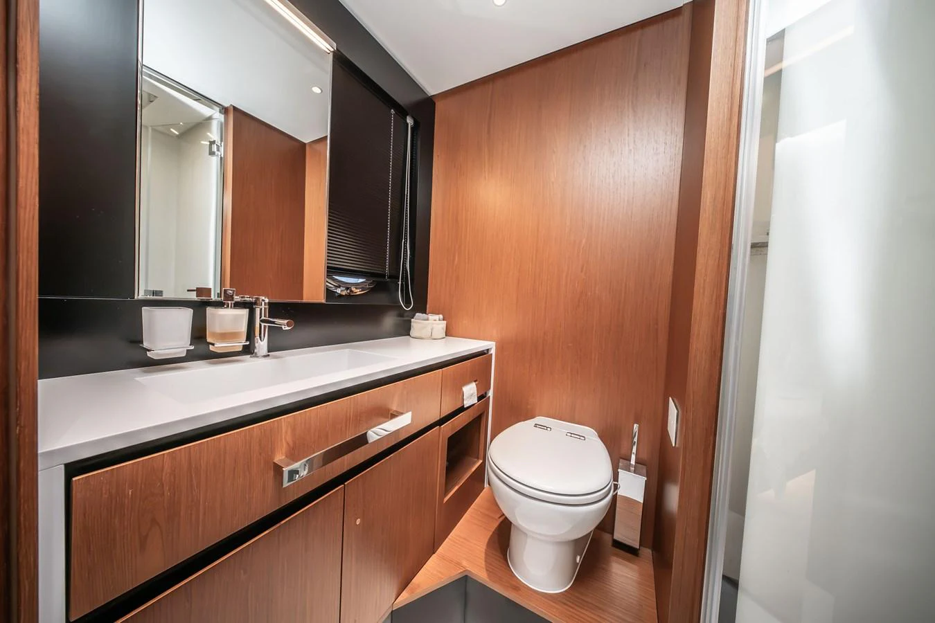 A modern yacht bathroom featuring sleek wood paneling and contemporary fixtures. aboard CREA Yacht for Sale