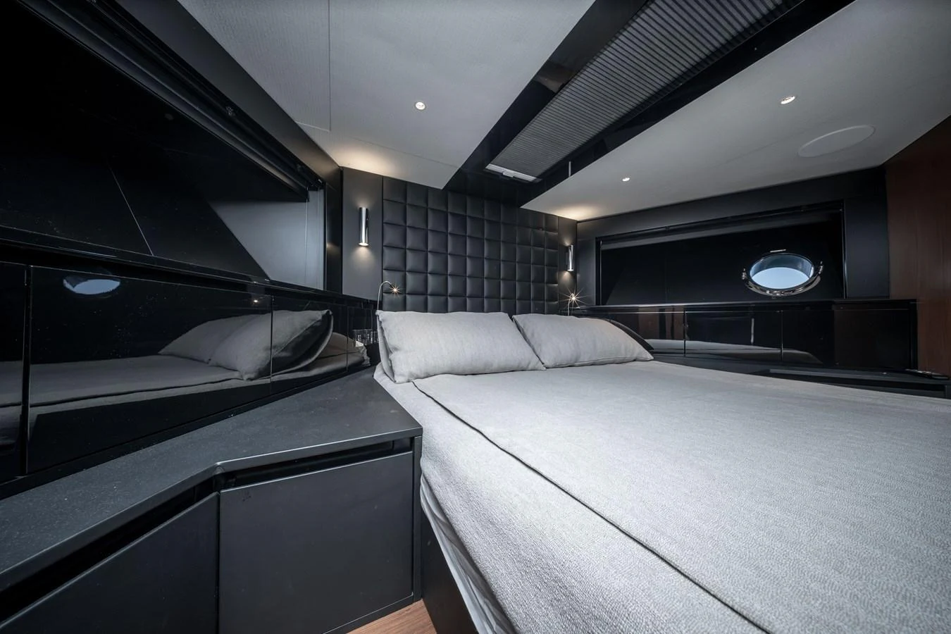 The stateroom features a modern design with sleek black accents and a comfortable bed. aboard CREA Yacht for Sale