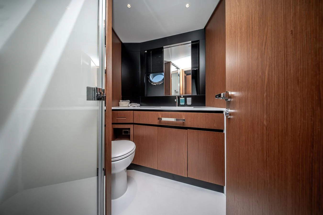 The yacht's bathroom features modern wood cabinetry and a sleek design. aboard CREA Yacht for Sale