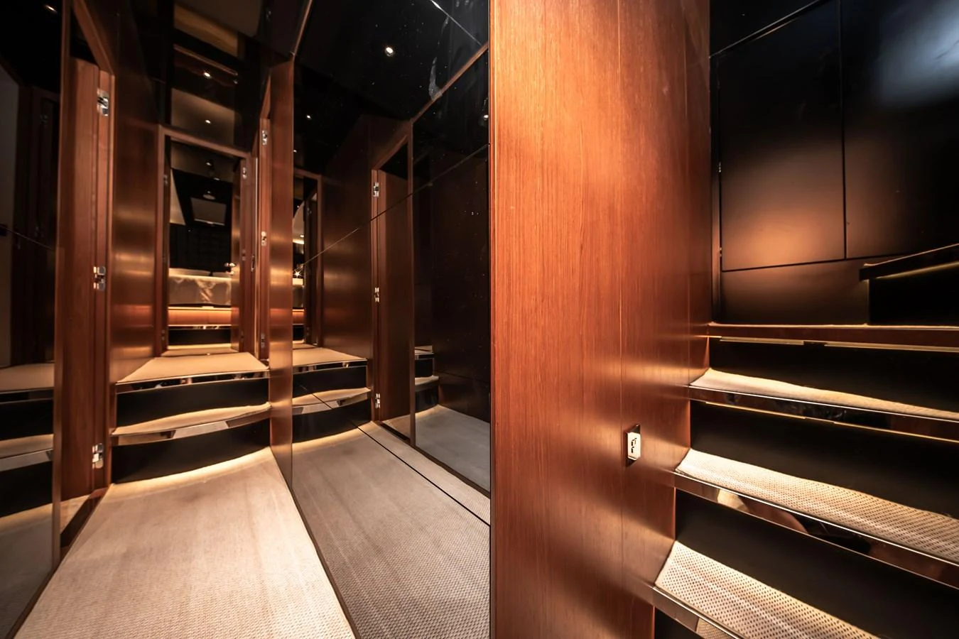 The yacht's interior features a sleek and modern design with wooden accents and mirrored surfaces. aboard CREA Yacht for Sale