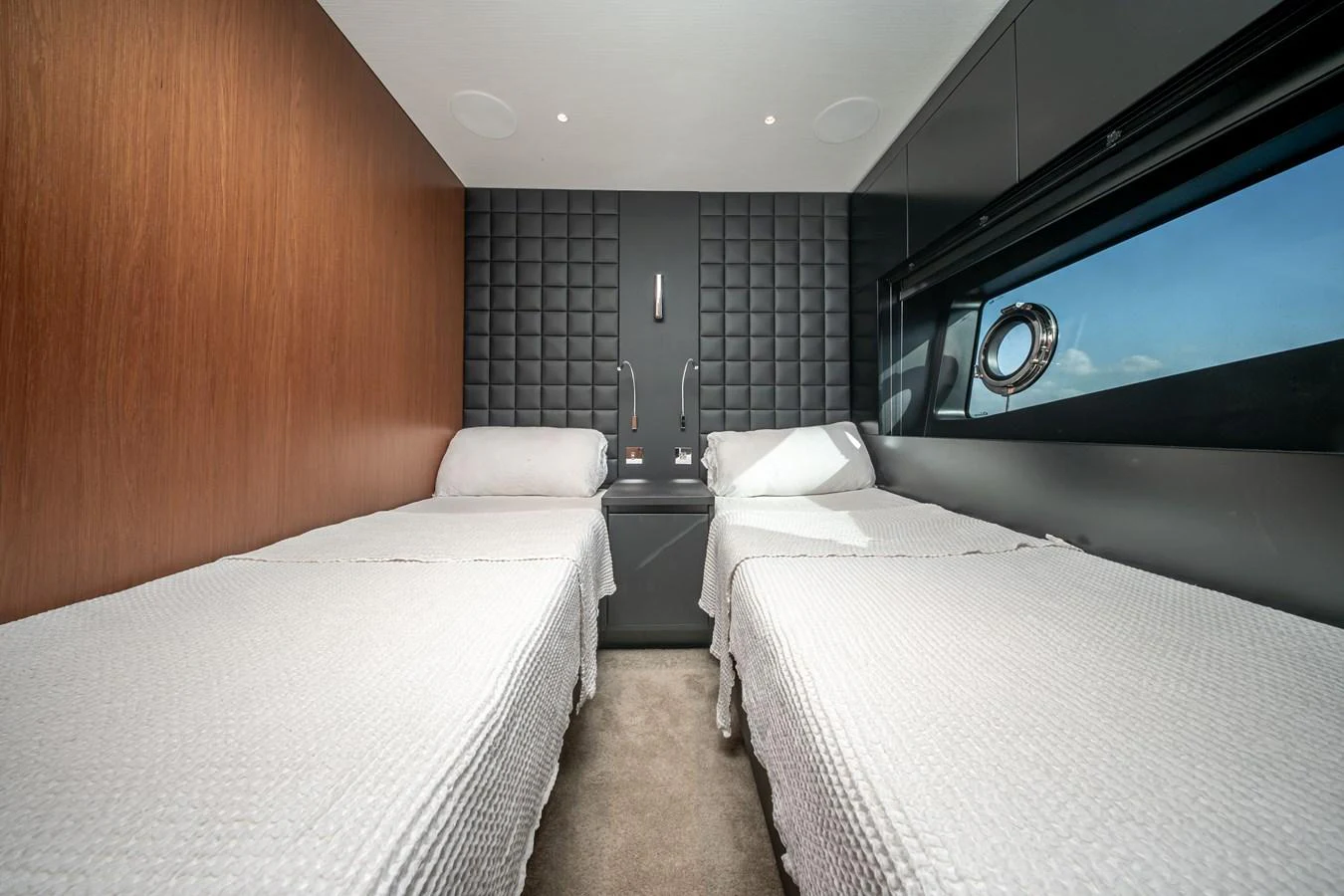 The twin stateroom features modern design elements with two single beds and a sleek, contemporary aesthetic. aboard CREA Yacht for Sale