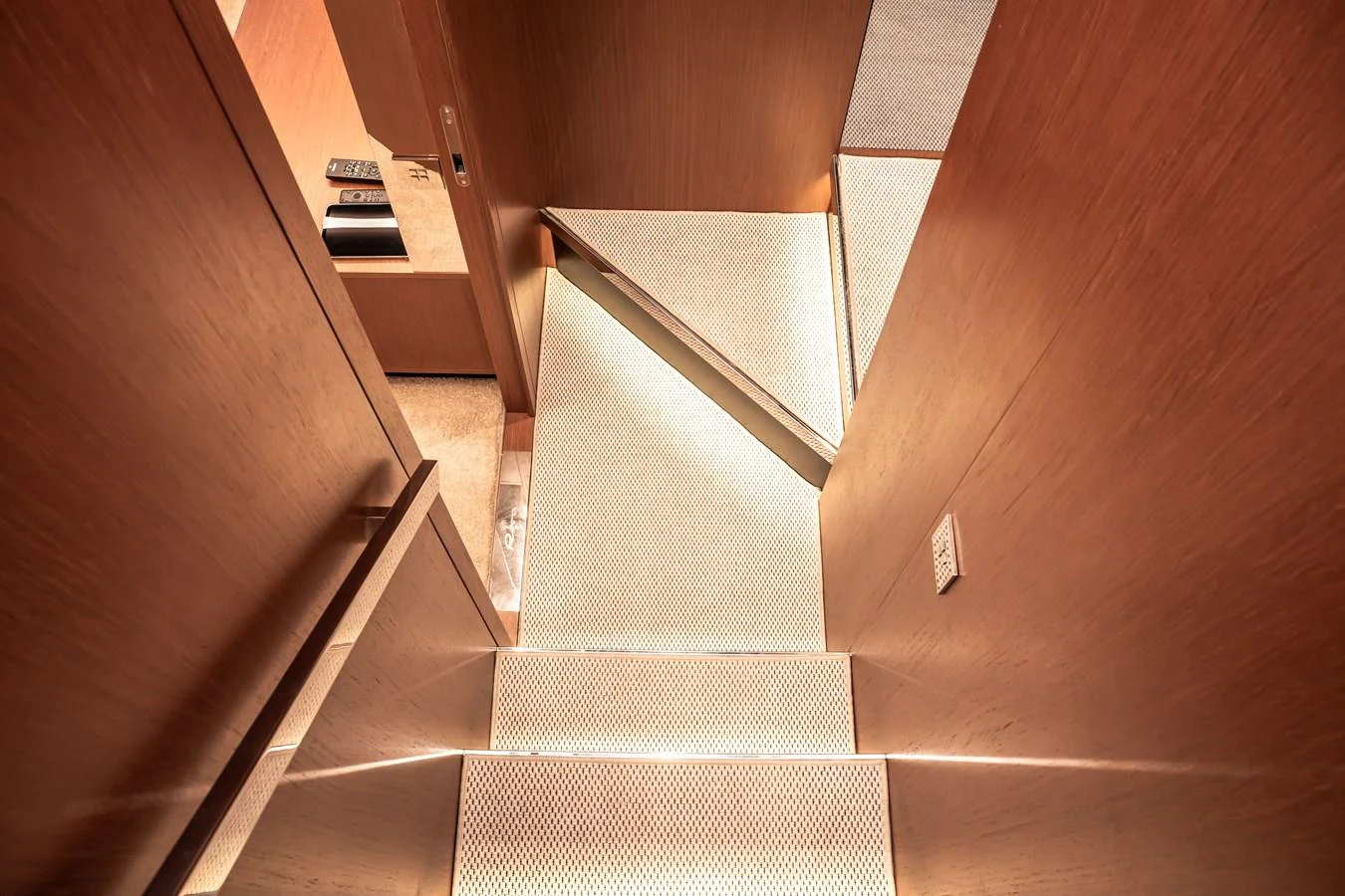The yacht features a modern, well-lit staircase with wooden paneling and sleek design. aboard CREA Yacht for Sale