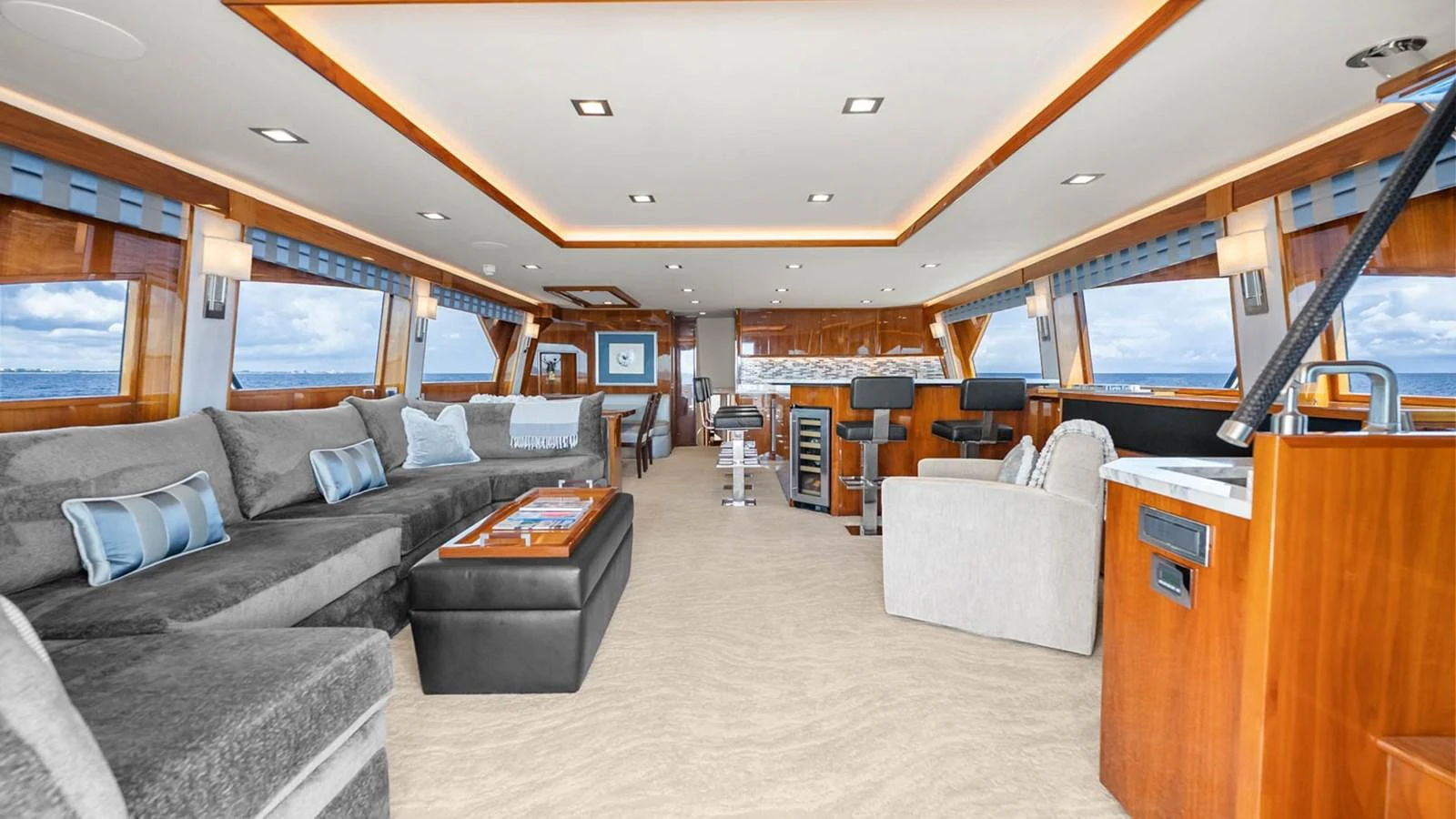The spacious salon features luxurious seating, elegant wood finishes, and panoramic windows offering stunning ocean views. aboard DOUBLE BARREL Yacht for Sale