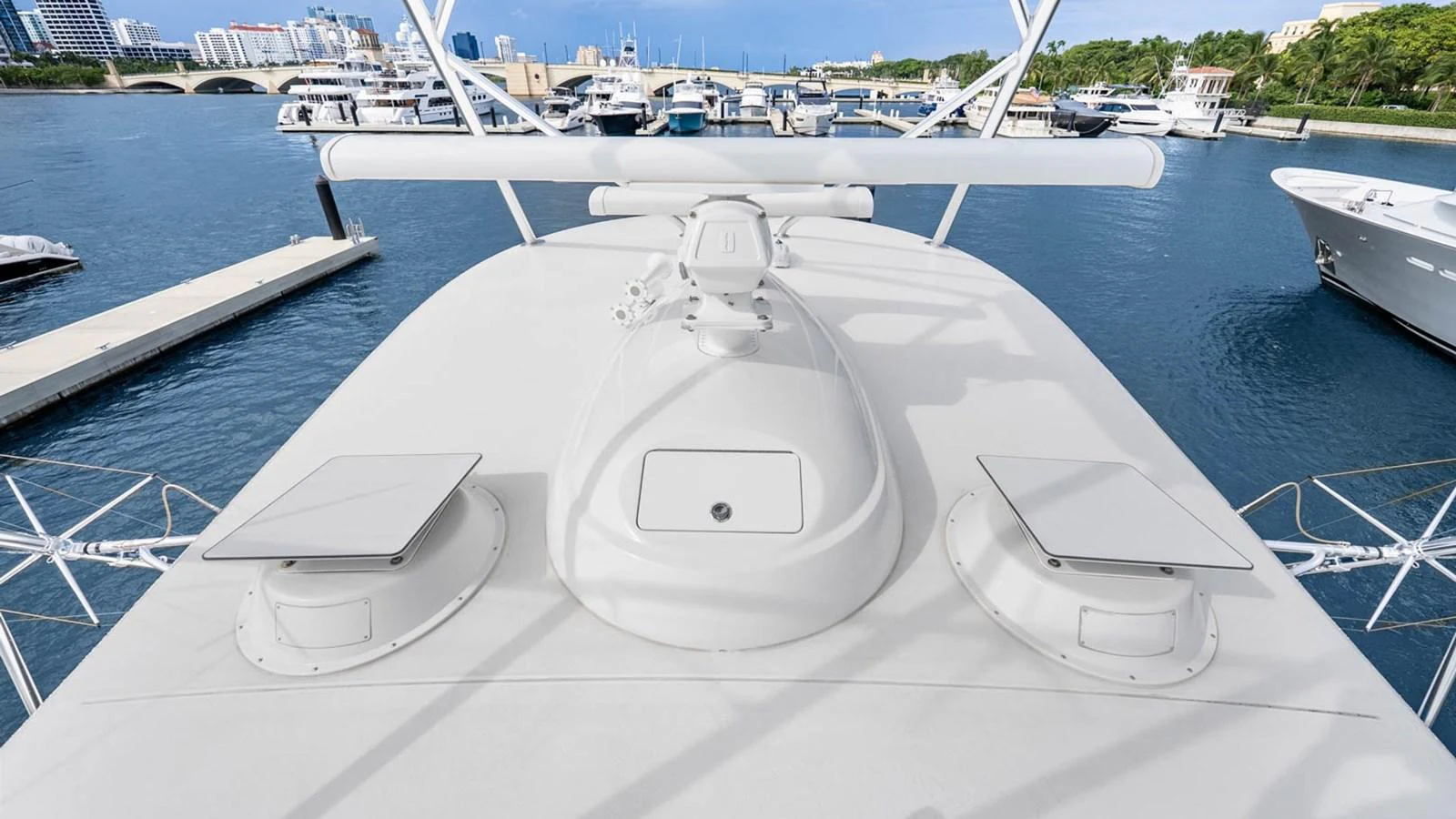 The yacht's bow offers a spacious and clean deck area with a scenic marina backdrop. aboard DOUBLE BARREL Yacht for Sale
