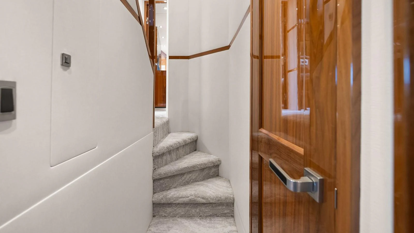 A well-lit interior hallway with a staircase leading to another level. aboard DOUBLE BARREL Yacht for Sale