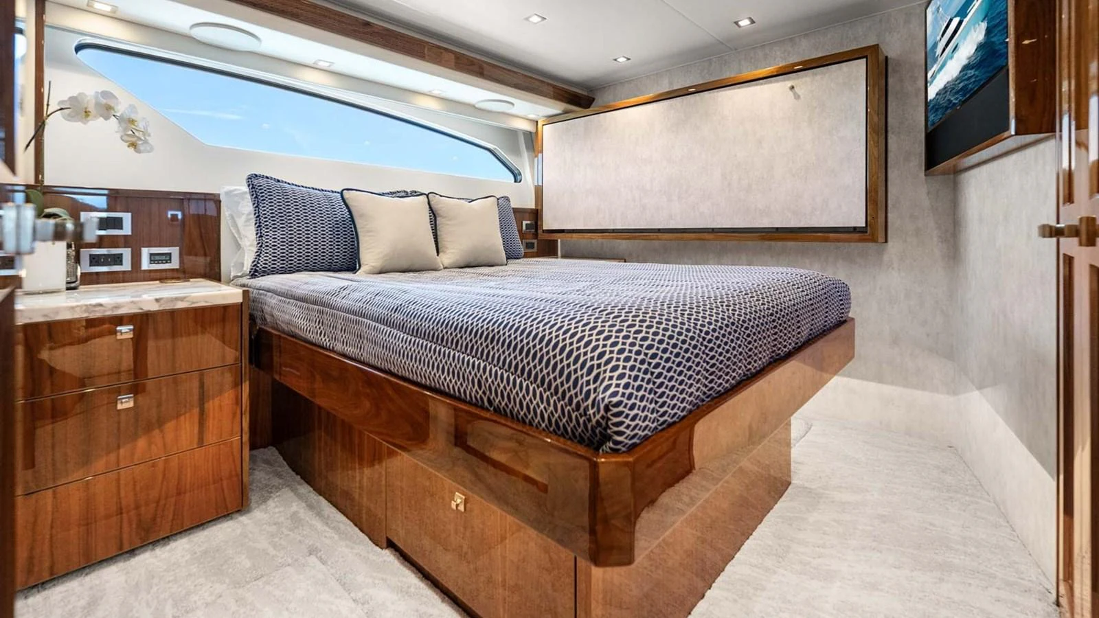 The stateroom features a luxurious bed with elegant wood finishes and modern amenities. aboard DOUBLE BARREL Yacht for Sale