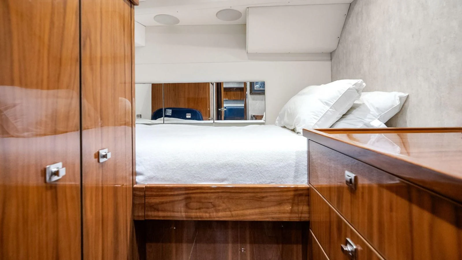 A cozy stateroom featuring polished wood cabinetry and a comfortable bed with white linens. aboard DOUBLE BARREL Yacht for Sale