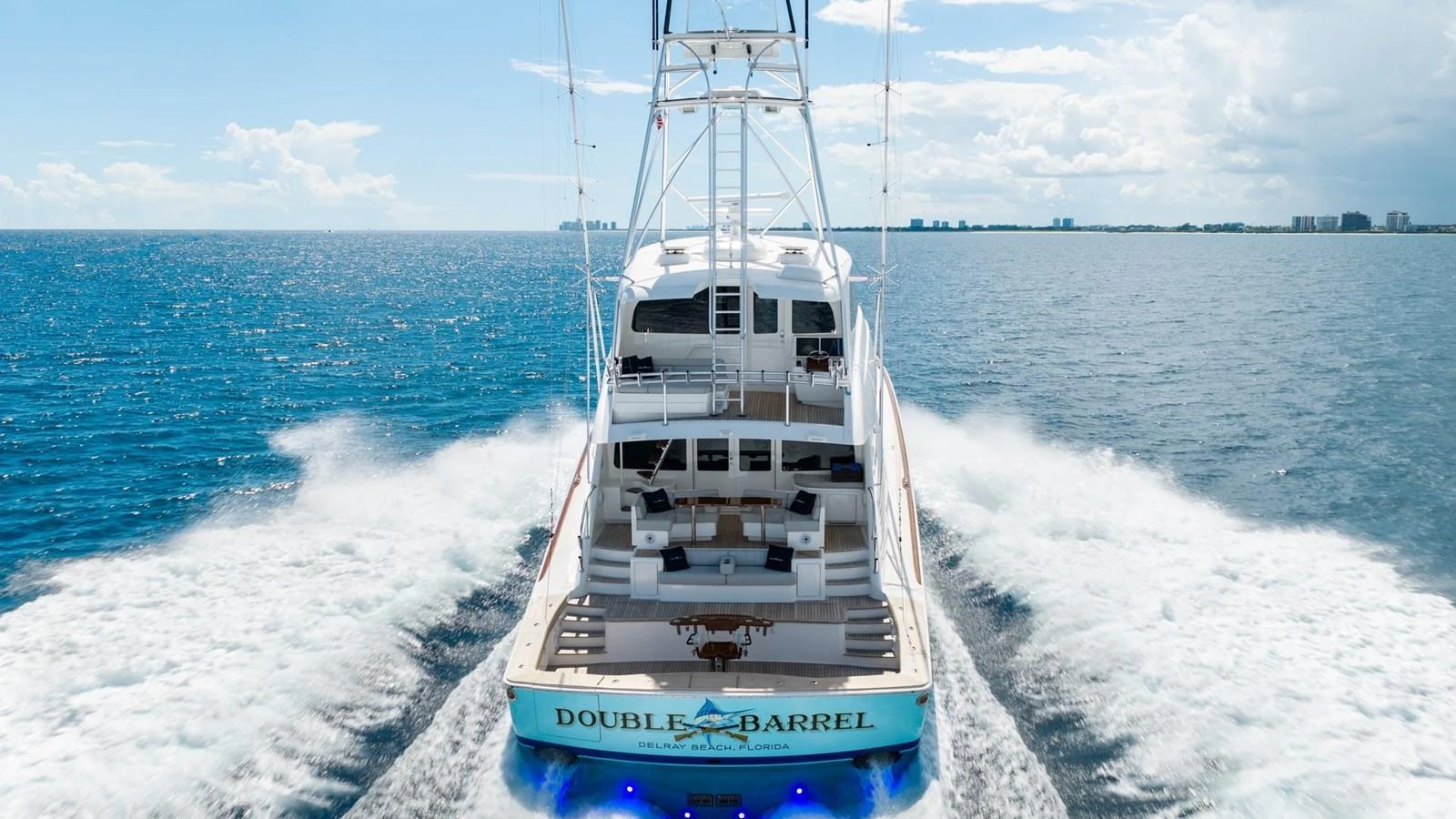 A luxurious yacht cruises through open waters, leaving a trail of white foam behind. aboard DOUBLE BARREL Yacht for Sale