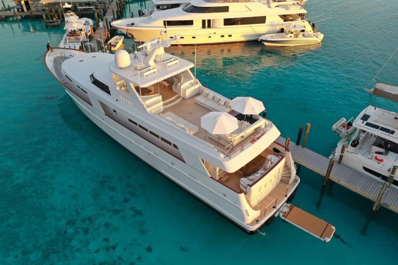 A luxurious yacht is docked in a serene marina with crystal-clear waters. aboard UKARA Yacht for Sale