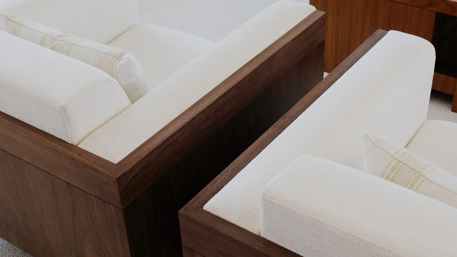 The image showcases a pair of luxurious, cream-colored sofas with wooden frames, highlighting the yacht's elegant interior design. aboard UKARA Yacht for Sale