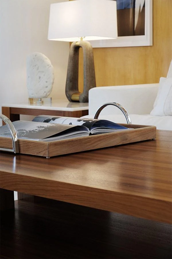 A stylish interior setting featuring a wooden coffee table with a decorative book and a modern lamp. aboard UKARA Yacht for Sale