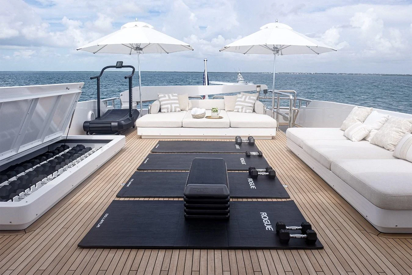 The sundeck is equipped with a luxurious outdoor gym setup, featuring comfortable seating and stunning ocean views. aboard UKARA Yacht for Sale
