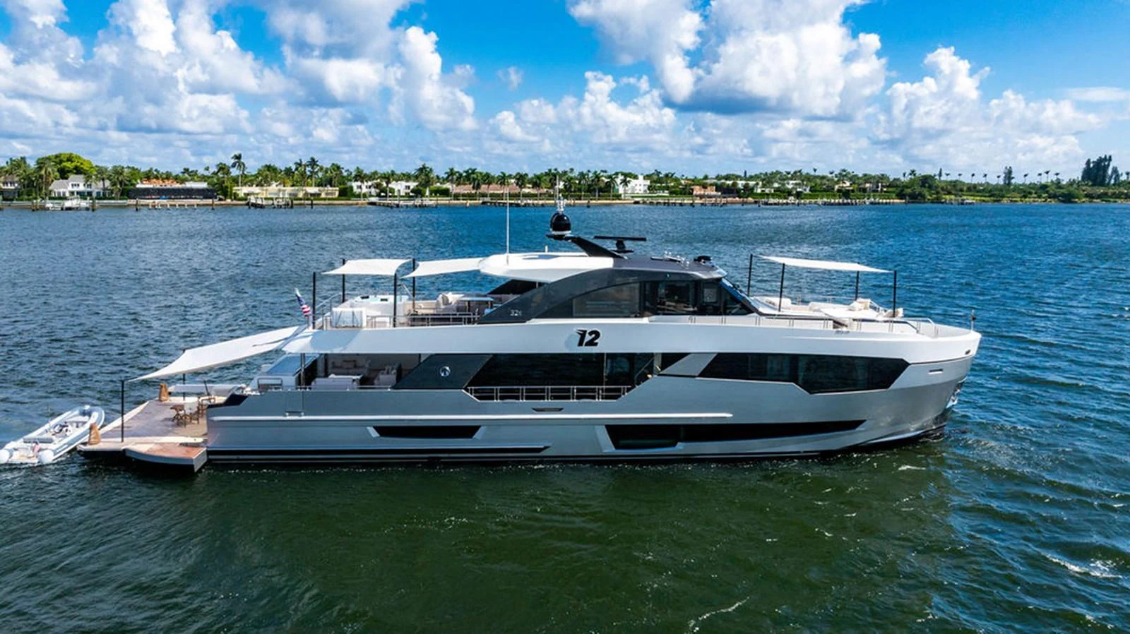 A sleek and modern yacht cruising on calm waters under a bright blue sky. aboard M/Y 12 Yacht for Sale
