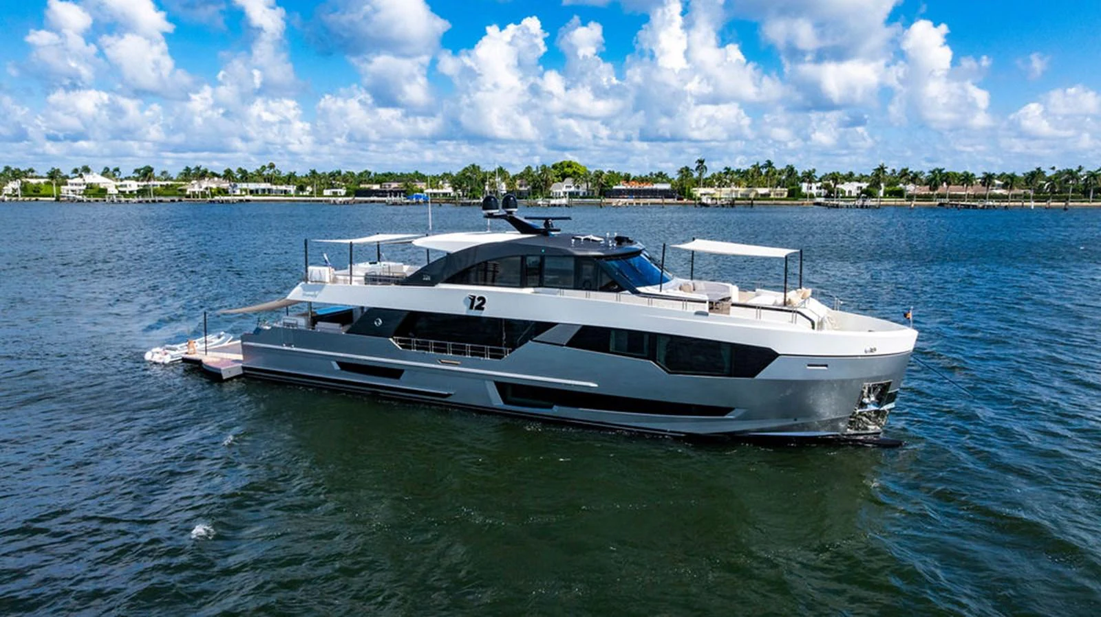 A sleek and modern yacht cruising on calm waters under a bright blue sky. aboard M/Y 12 Yacht for Sale