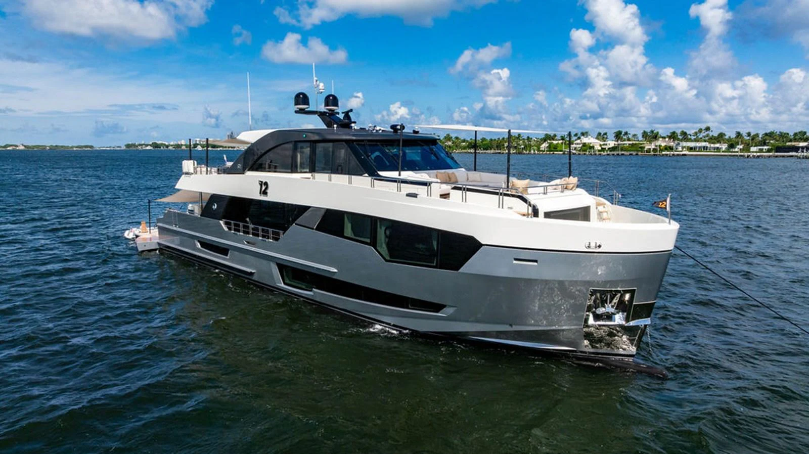 A sleek and modern yacht cruising on calm waters under a bright blue sky. aboard M/Y 12 Yacht for Sale
