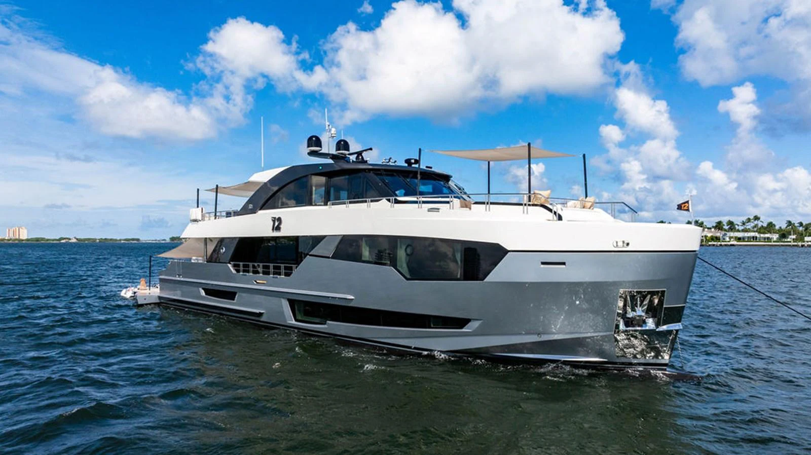 A sleek and modern yacht glides gracefully on the water under a bright blue sky. aboard M/Y 12 Yacht for Sale