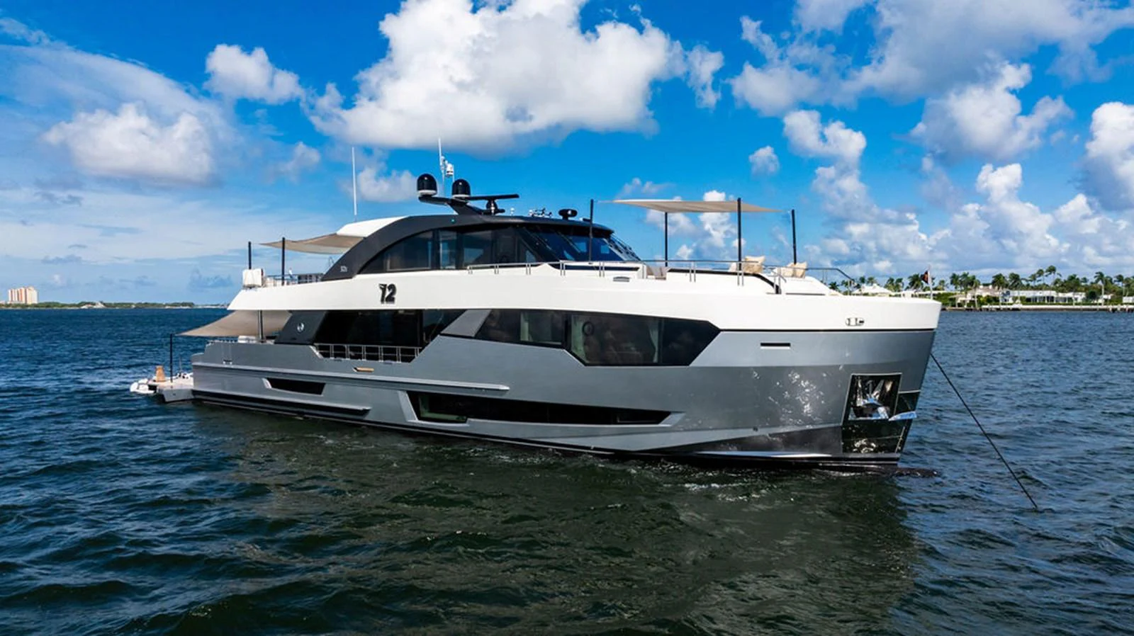 A sleek and modern yacht cruising on calm waters under a bright blue sky. aboard M/Y 12 Yacht for Sale