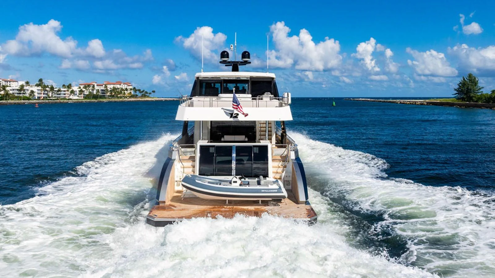 A luxurious yacht cruises through clear blue waters, showcasing its sleek design and spacious deck. aboard M/Y 12 Yacht for Sale