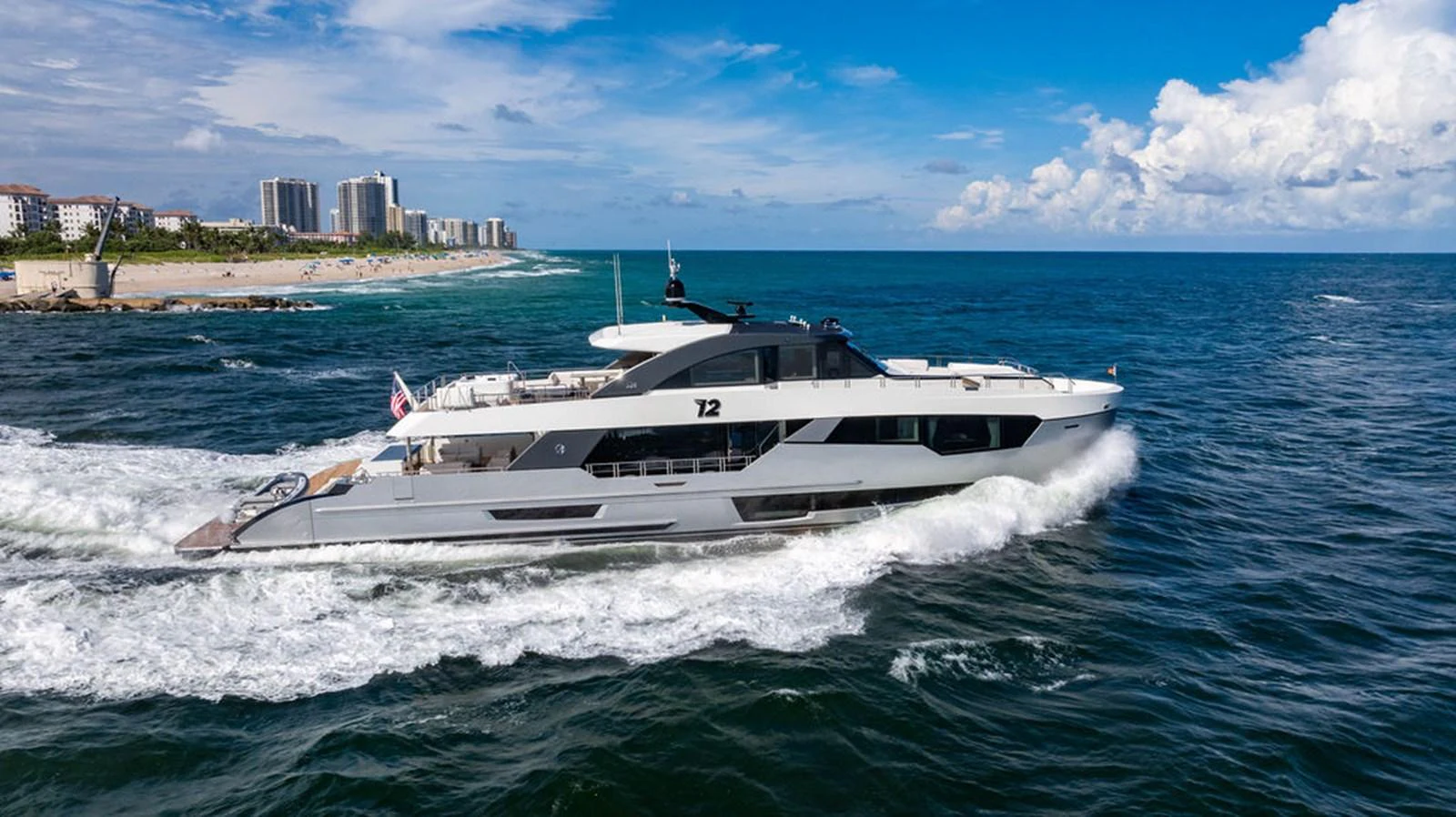 A sleek yacht cruises through the ocean with a scenic coastline in the background. aboard M/Y 12 Yacht for Sale