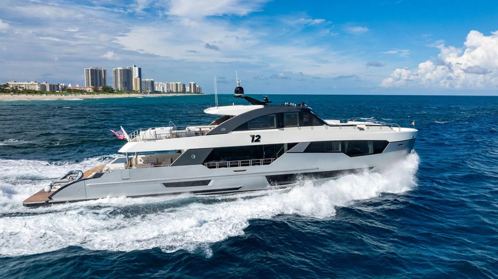A sleek and modern yacht cruises through the open sea under a clear blue sky. aboard M/Y 12 Yacht for Sale