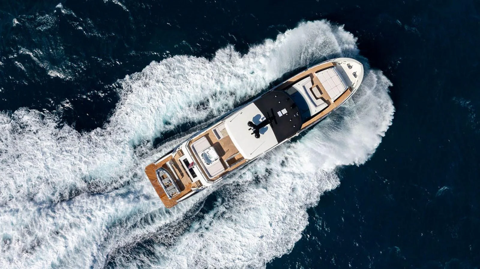 An aerial view of a luxurious yacht cruising through the open sea, showcasing its sleek design and spacious deck areas. aboard M/Y 12 Yacht for Sale