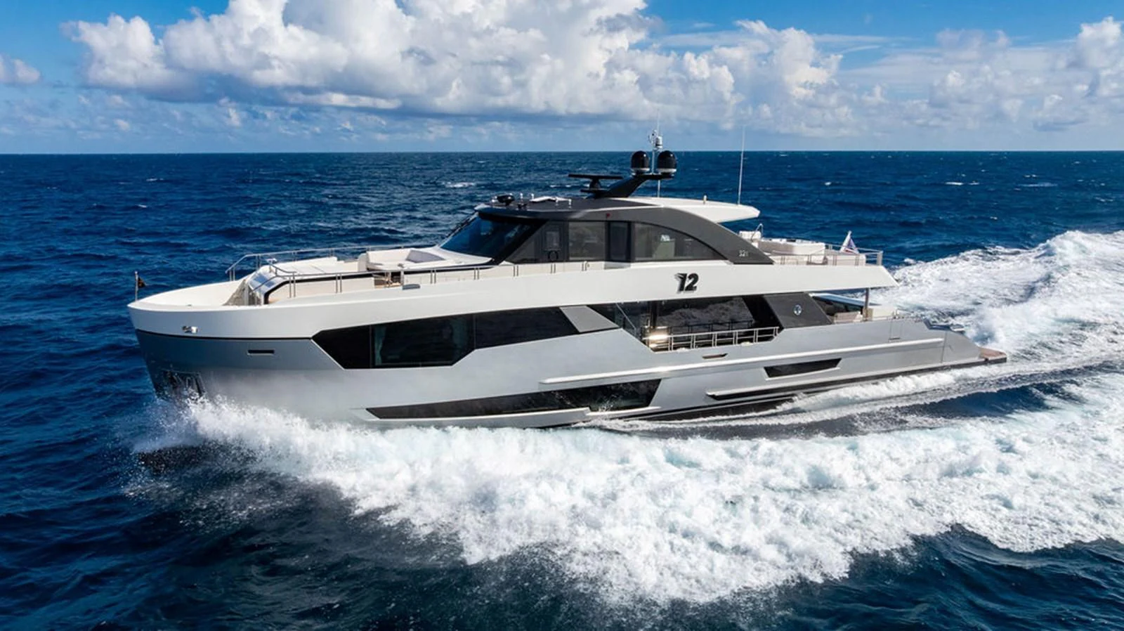 A sleek and modern yacht cruises through the open ocean under a bright blue sky. aboard M/Y 12 Yacht for Sale