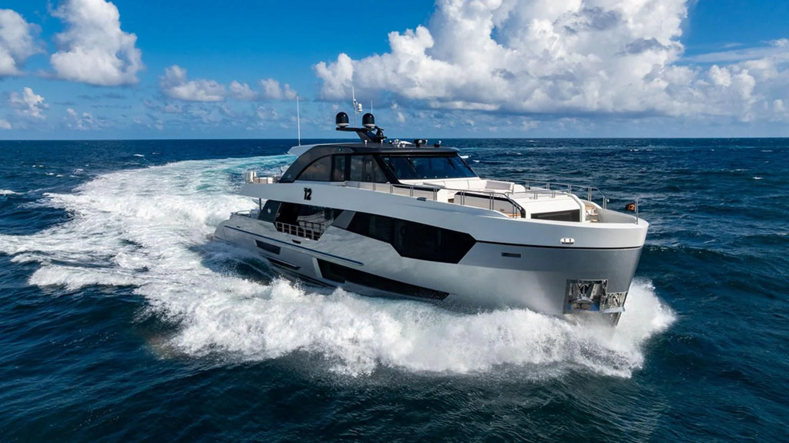 A sleek and modern yacht cruises through the open sea under a bright blue sky. aboard M/Y 12 Yacht for Sale