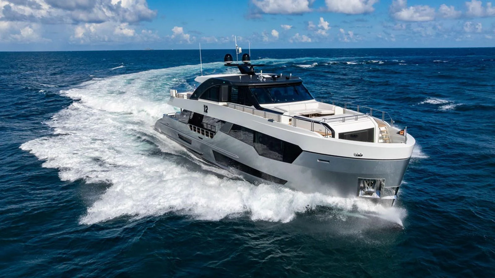 A sleek and modern yacht cruising through open waters under a bright sky. aboard M/Y 12 Yacht for Sale